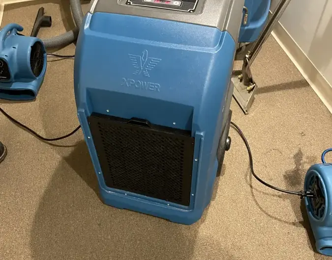 Dehumidifier and air movers drying a carpeted room after water damage in Dublin, CA
