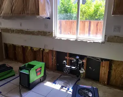 Kitchen cabinets opened up with drying equipment after an appliance leak in Dublin, CA