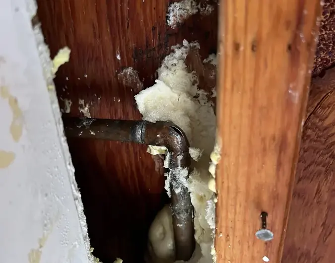 Corroded pipe exposed inside an opened wall after a burst pipe in Dublin, CA